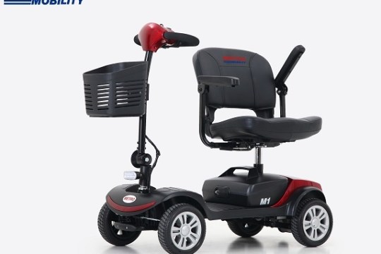 Red and black mobility scooter with a front basket on a white background.